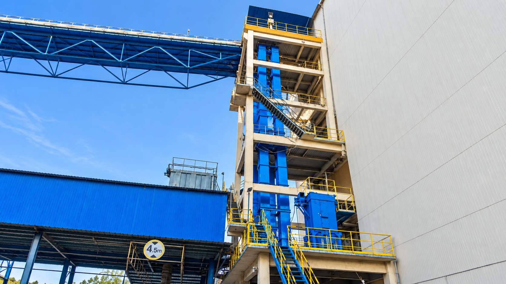 NE plate-chain bucket elevator connected to an industrial material handling line